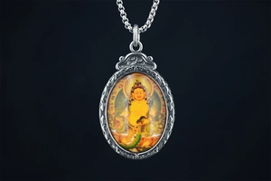 Détail macro du pendentif bouddhiste Jambhala jaune avec cadre en argent vintage gaufré