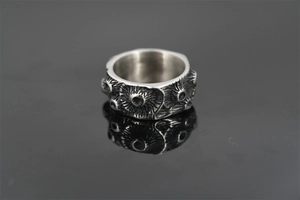Macro shot of silver retro punk ring with textured industrial crater relief detail
