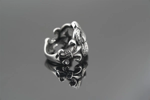 Macro detail of gothic Fleur-de-lis engraving on oxidized vintage steel ring