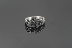 Detailed macro view of vintage silver wing ring with intricate feather texture engraving
