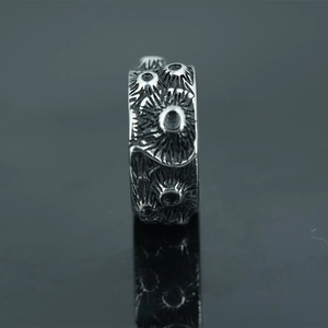 Punk style vintage titanium steel ring with volcanic rock texture on dark background