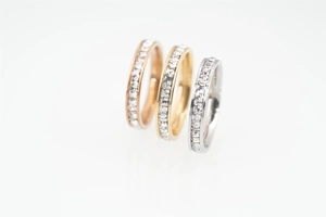 Detailed macro view of square-cut crystals set in gold, rose gold and silver bands