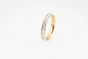 Detailed close-up of golden eternity ring featuring square-cut white zircon stones