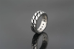 Macro shot of silver tire tread texture and oxidized finish on a titanium steel ring