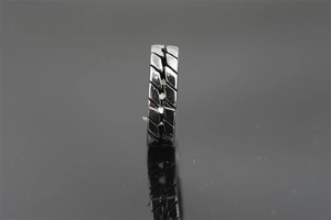 Macro detail of industrial tire tread design on high polished titanium steel ring