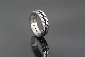 Macro detail of industrial tire tread texture and vintage finish on a titanium steel ring