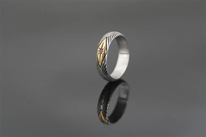 Macro view of vintage silver ring with feather textures and gold rhombus ruby setting