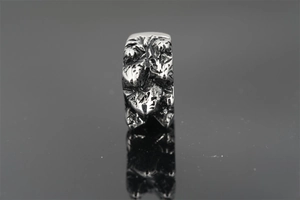 Macro shot of vintage hill-textured stainless steel ring with industrial rock pattern