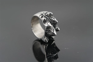 Macro detail of retro 3D mountain texture and oxidized finish on stainless steel ring