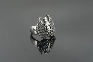 Detailed view of punk style sword and angel wings carved on a vintage steel ring