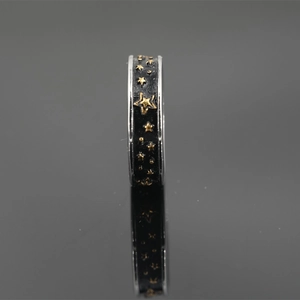 Anello vintage in acciaio al titanio con stelle dorate su finitura nera opaca e riflesso