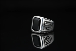 Macro d'une bague vintage en acier titane pour homme avec pierre noire et gravure