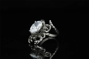 Detailed view of crab shaped silver ring with oval clear zircon and polished finish