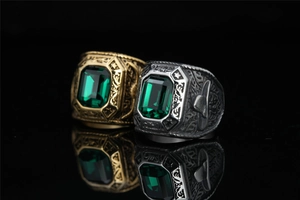Detailed macro view of vintage eagle rings with emerald green gemstones and ornate engravings