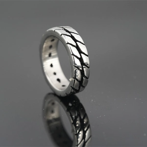 Retro stainless steel tire tread ring with silver textured finish and unique side cutouts