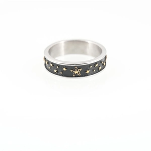 Anello vintage in acciaio al titanio con smalto nero e stelle dorate su sfondo bianco
