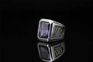Gros plan d'une bague en titane pour homme avec pierre violette et détails gravés