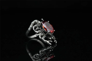 Macro shot of gothic spider ring with deep red oval crystal in antiqued silver finish