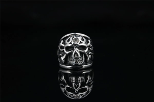 Gothic silver skull ring detail with white zircon stone inlay and punk mirror reflection