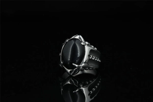 Vue macro de la bague gothique en acier avec onyx noir poli et détails de griffes ciselées
