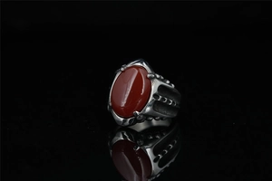 Détail macro d'une bague punk vintage avec une grande agate rouge ovale et un anneau texturé
