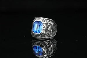 Detail of vintage eagle-style ring with engraved silver metal and a large blue gem