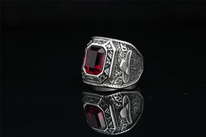 Macro view of emerald-cut ruby stone and embossed relief on titanium steel ring