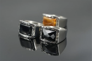 Macro detail of men's retro steel rings with tiger eye and black onyx inlays