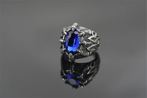 Detail van herenring met blauwe edelsteen en zetting in de vorm van drakenklauwen