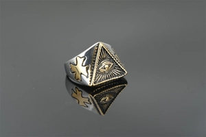Macro detail of vintage punk Eye of Horus ring with golden pyramid and cross symbols