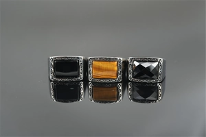 Macro shot of three vintage steel signet rings with tiger eye and black agate inlays