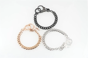 Detail of three stainless steel handcuff-style bracelets in black, rose gold, and silver