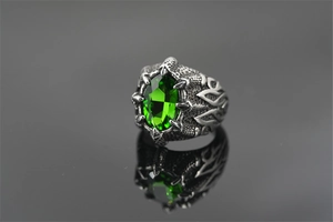 Macro detail van een drakenklauw ring voor heren met een grote ovale groene edelsteen