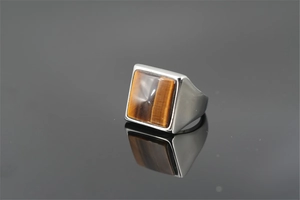 Vue détaillée d'une bague pour homme en acier titane avec œil de tigre sur fond noir