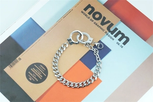 Detail view of steel cuban link handcuff bracelet with UNLOCK engraving on the lock