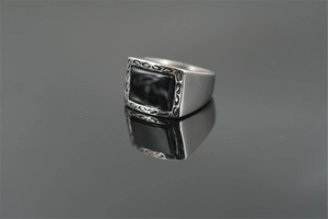 Detail of vintage silver titanium steel ring with rectangular black onyx stone and engravings