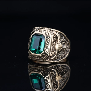 Vintage eagle titanium steel ring with emerald green stone on black reflective background
