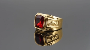 Macro detail of men's gold plated dragon ring with a large rectangular red ruby gemstone