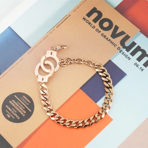 Rose gold handcuff cuban chain bracelet on a design magazine with unique unlock engraving