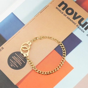 Gold stainless steel handcuffs bracelet with a chunky Cuban chain and adjustable lobster clasp