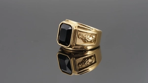 Detailed view of men's gold plated ring with rectangle black stone and Pixiu relief