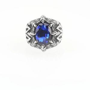 Gothic herenring met diepblauwe saffieren oog gezet in gedetailleerde drakenklauwen