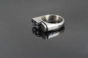 Macro detail of silver lighter-shaped ring with mechanical gears and industrial design