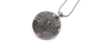 Detail of vintage silver eagle pendant with hammered texture and classic box chain