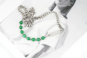 Detail of OT buckle necklace with green beads and engraved metal plate on chain