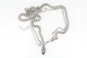 Detail of layered titanium steel necklace featuring Virgin Mary pendant and curb chain
