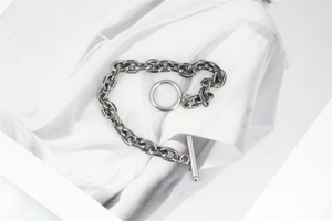 Dettaglio della chiusura a barra in argento vintage e maglie spesse del bracciale in metallo
