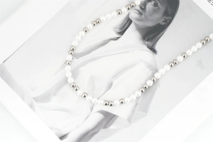 Detail of alternating white pearls and silver steel beads on a trendy necklace