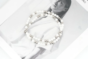 Close-up of double-layer necklace with white faux pearls and silver steel beads