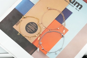 Vue détaillée des pendentifs étoile et tour Eiffel sur des bracelets en acier titane